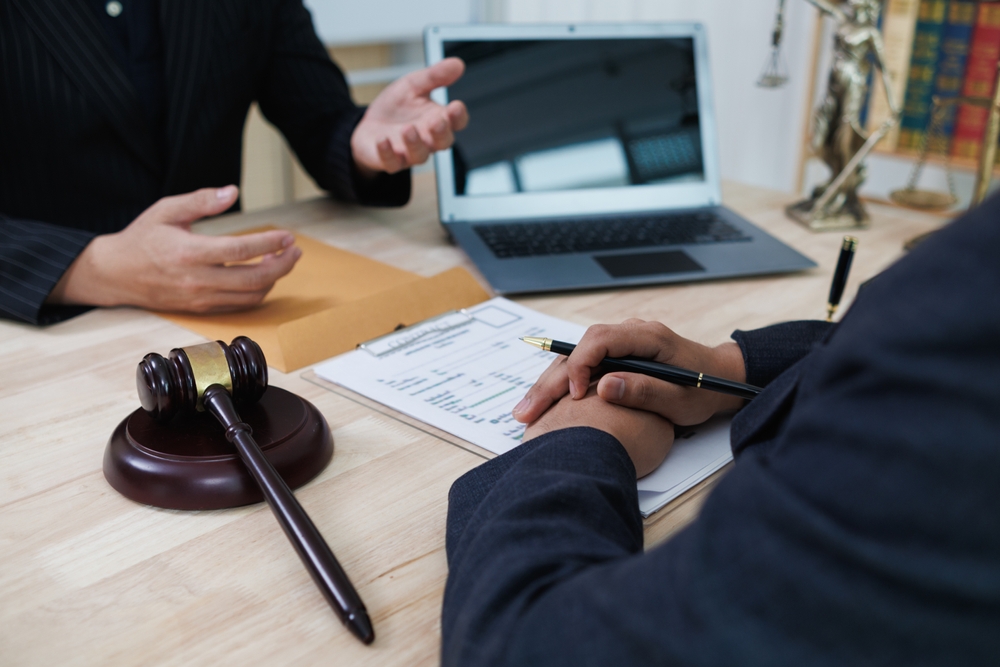 A client consults with a lawyer in a legal office for advice on recoverable damages in a car accident case.