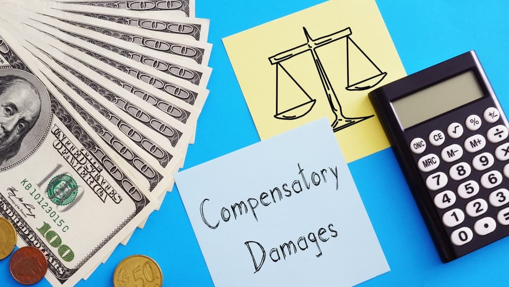 The phrase "Compensatory Damages" is displayed in bold text, symbolizing the financial restitution awarded to cover losses and injuries in legal claims.