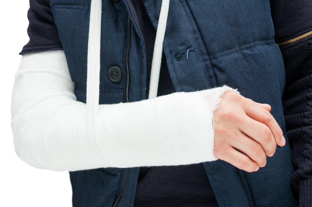 A close-up image of a hand wrapped in a bandage and covered with a plaster cast, symbolizing the concept of bodily injury and recovery after an accident.