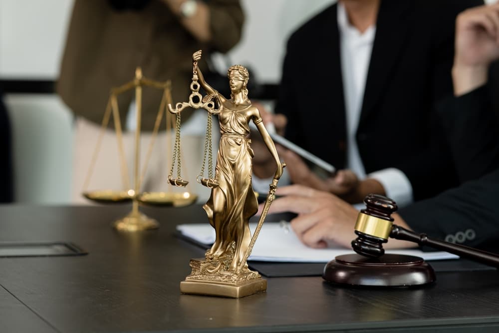 A lawyer in a meeting, focused and working at a desk in an office setting, representing the concept of law and justice. The scene emphasizes professionalism and attention to legal matters with selective focus.