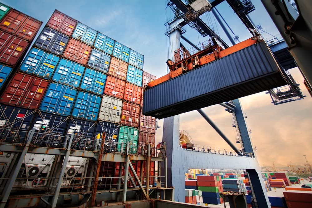 Loading containers onto a cargo freight ship using an industrial crane. The container ship is part of the import and export logistics business.