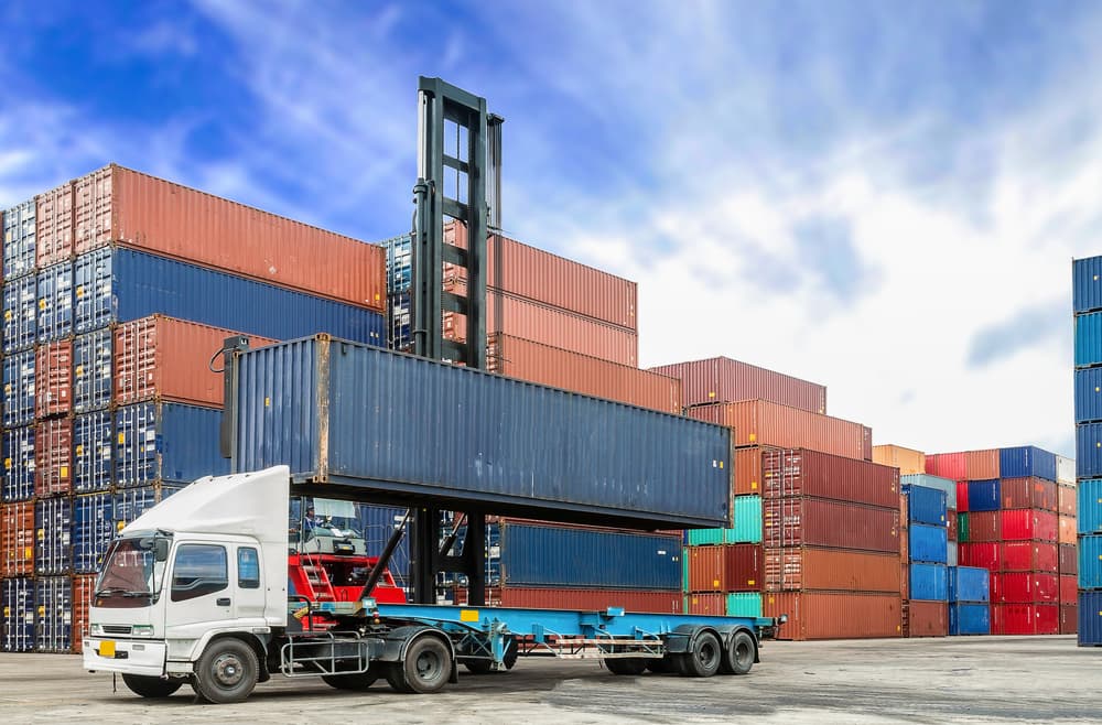 Containers at the docks being loaded onto a truck.